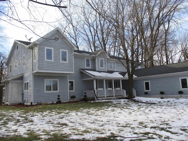 snow covered property featuring covered porch