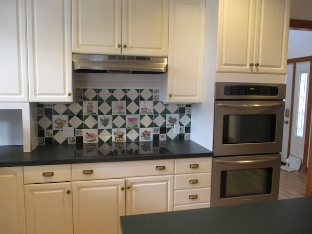 kitchen with stainless steel double oven, white cabinets, and decorative backsplash