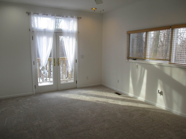 spare room with light carpet, ceiling fan, and french doors