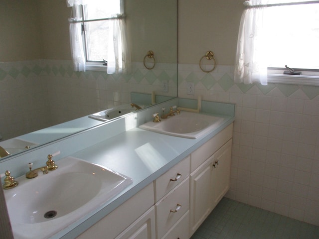 bathroom featuring vanity, tile patterned flooring, and tile walls