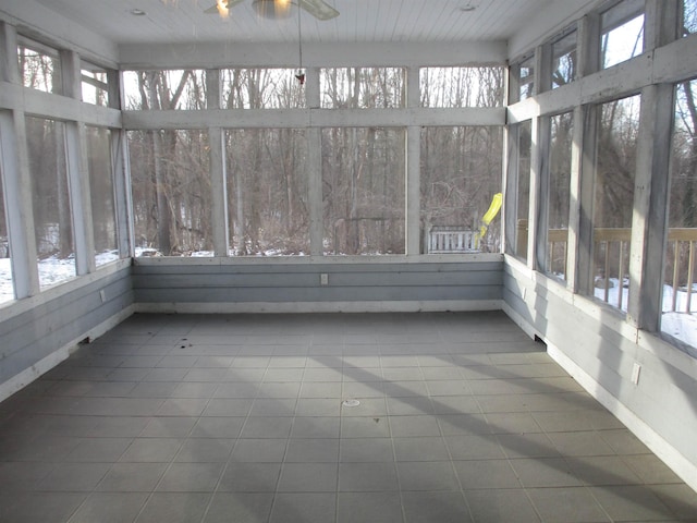 unfurnished sunroom with ceiling fan