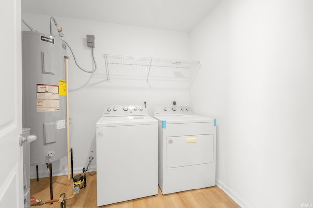 laundry room featuring separate washer and dryer, light hardwood / wood-style flooring, and water heater