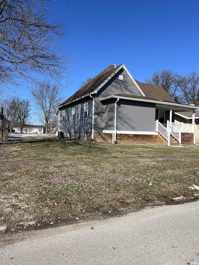 view of side of home featuring covered porch