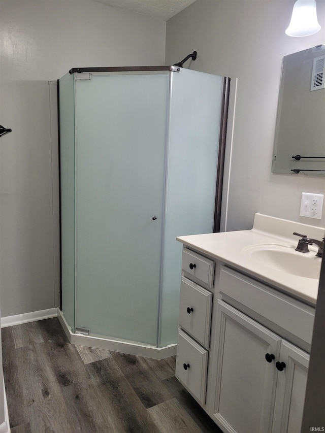 bathroom featuring vanity, hardwood / wood-style floors, and walk in shower