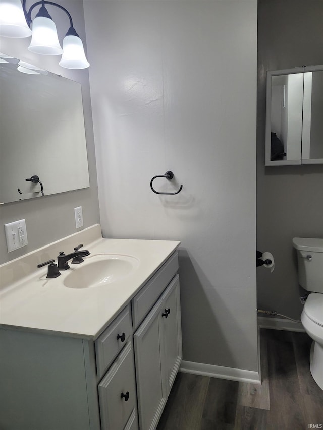 bathroom with vanity, hardwood / wood-style floors, and toilet