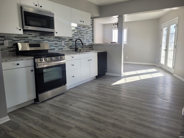 kitchen with sink, white cabinetry, tasteful backsplash, decorative light fixtures, and stainless steel appliances