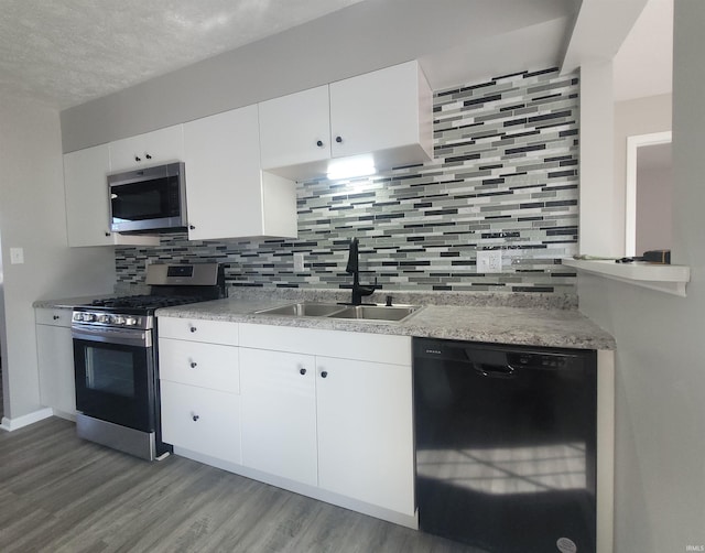 kitchen with tasteful backsplash, sink, stainless steel appliances, and white cabinets