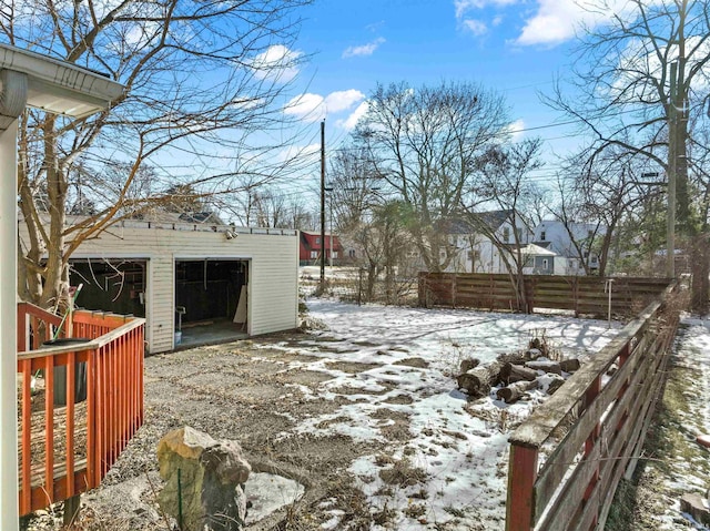 yard covered in snow with a garage and an outbuilding