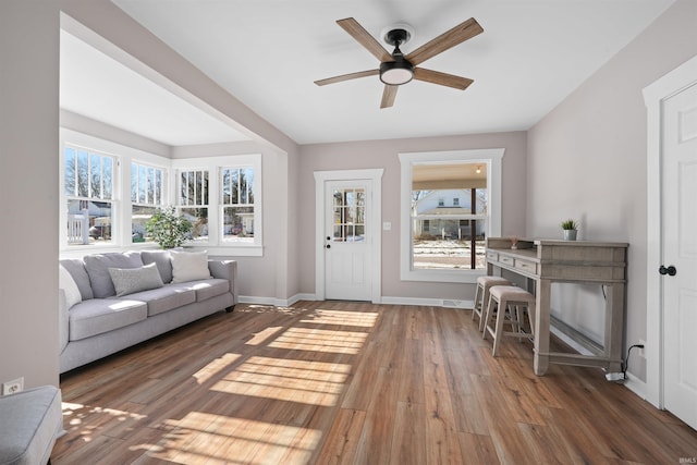 living room with dark hardwood / wood-style flooring and ceiling fan