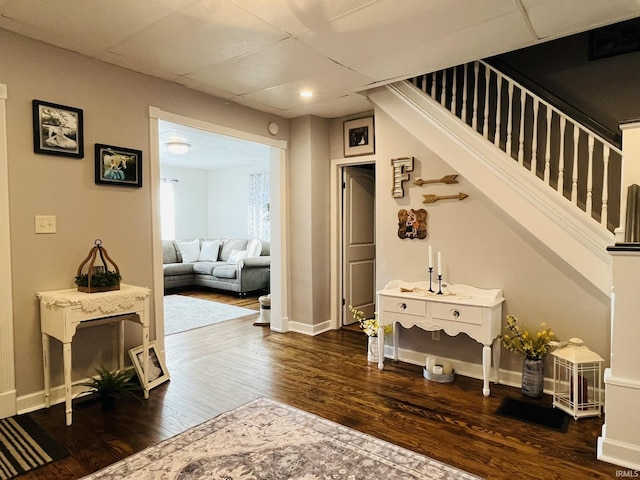 hallway featuring a drop ceiling and dark wood-type flooring