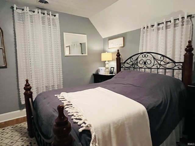 bedroom with vaulted ceiling and wood-type flooring