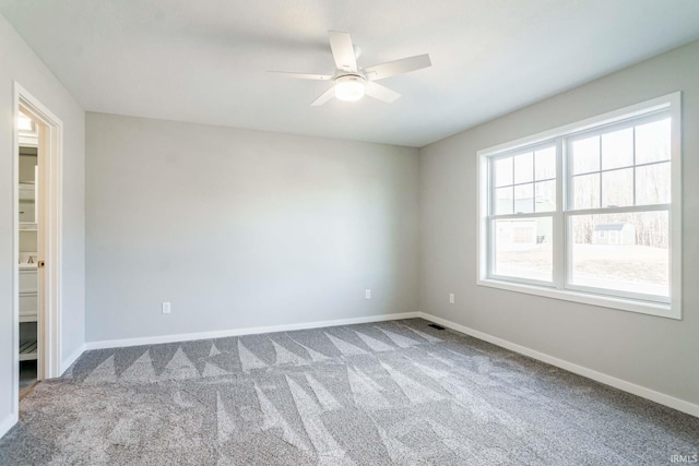 carpeted spare room featuring ceiling fan