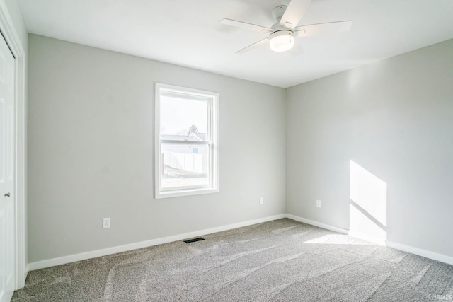 carpeted spare room featuring ceiling fan