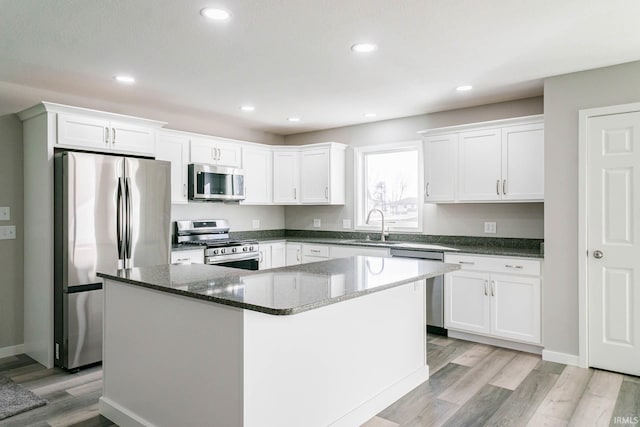 kitchen with stainless steel appliances, a center island, and white cabinets