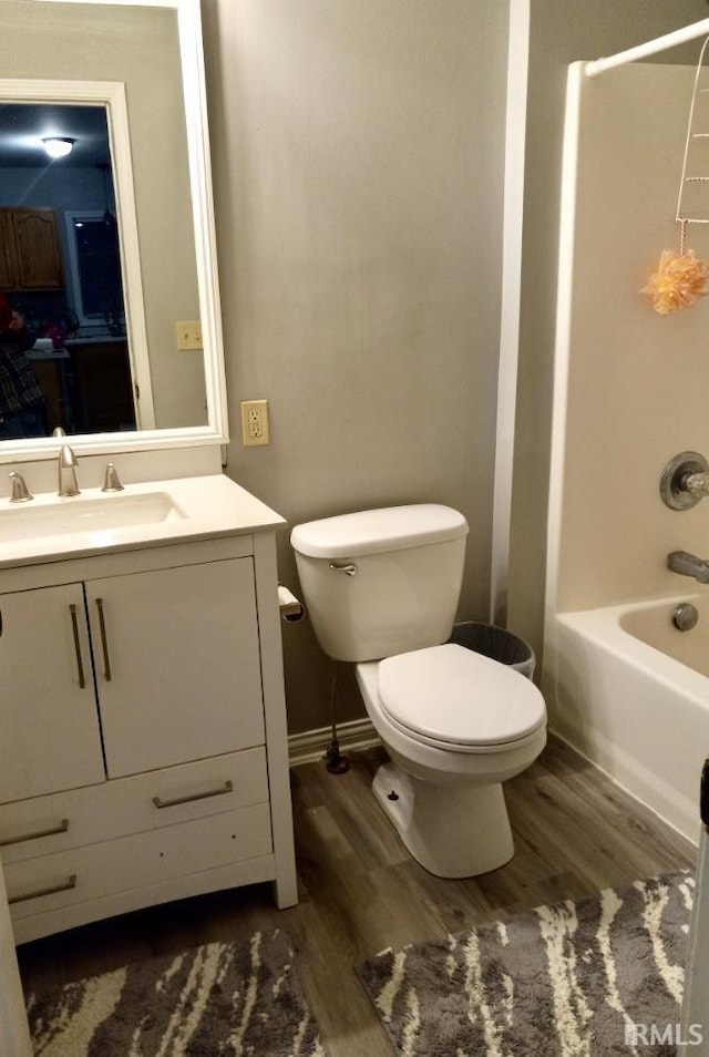 full bathroom featuring hardwood / wood-style flooring, vanity, shower / tub combination, and toilet