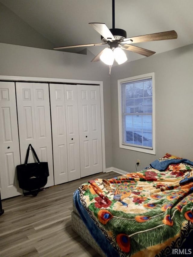 bedroom with vaulted ceiling, hardwood / wood-style floors, ceiling fan, and a closet