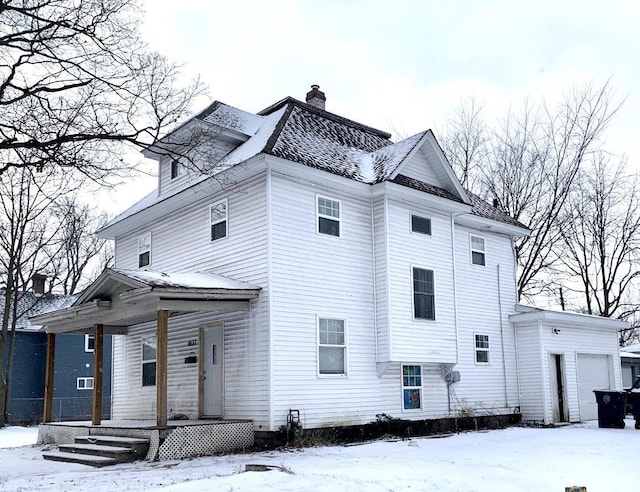 view of snow covered exterior featuring a garage