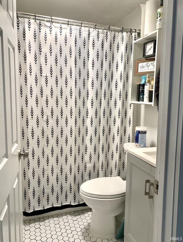 bathroom with tile patterned flooring, vanity, a shower with curtain, and toilet