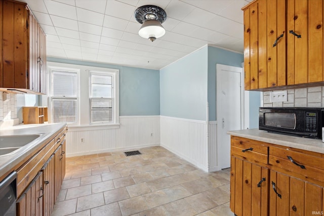 kitchen with sink, stainless steel dishwasher, and backsplash