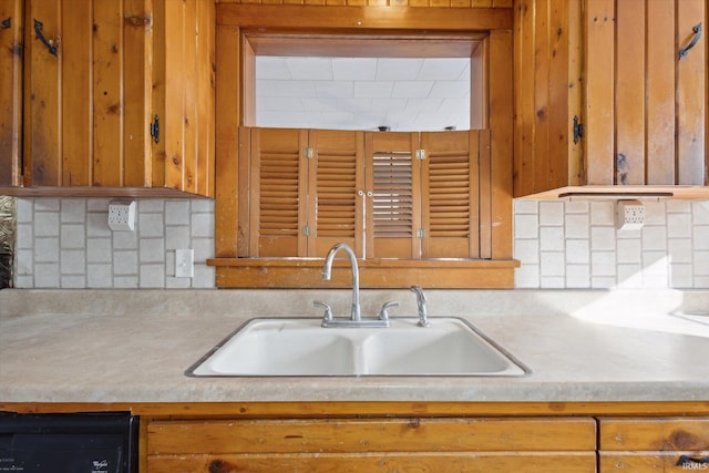 kitchen with dishwashing machine, sink, backsplash, and wooden walls