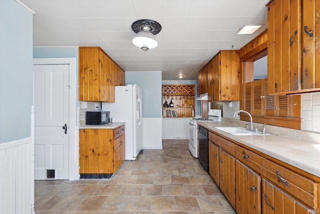 kitchen featuring sink, white appliances, and backsplash