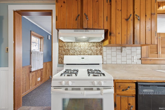 kitchen with crown molding, black dishwasher, white gas range, decorative backsplash, and wood walls