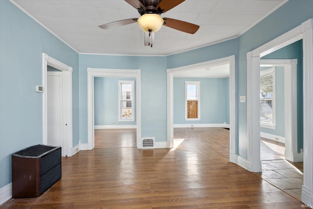 empty room with hardwood / wood-style flooring, ornamental molding, and ceiling fan