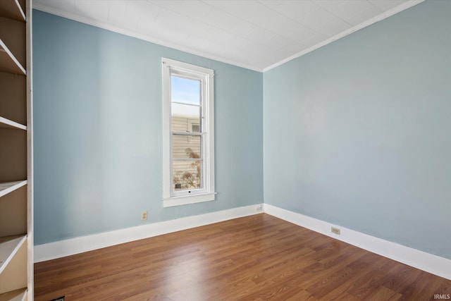 spare room featuring hardwood / wood-style flooring and crown molding