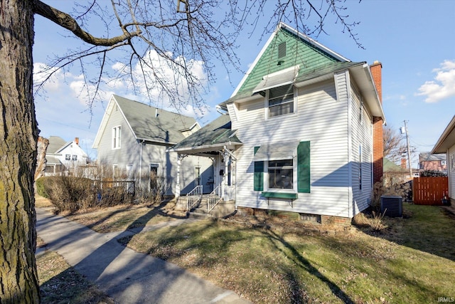 view of front facade with central AC unit and a front lawn