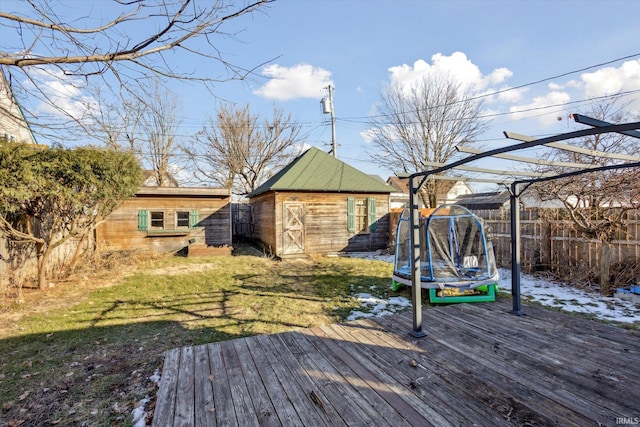 deck featuring a storage shed, a yard, and a trampoline