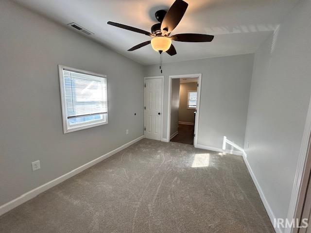 unfurnished bedroom with ceiling fan and carpet