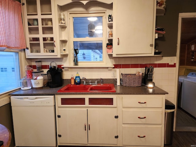 kitchen with tasteful backsplash, sink, white cabinets, washing machine and clothes dryer, and white dishwasher