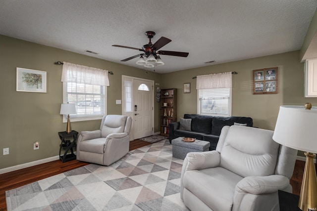 living room with ceiling fan, light hardwood / wood-style flooring, and a textured ceiling