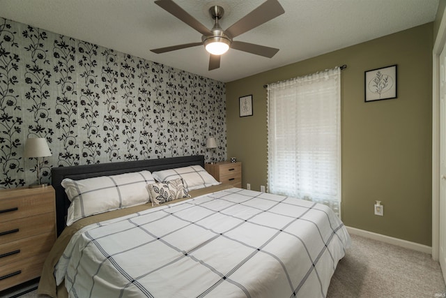 carpeted bedroom featuring ceiling fan and a textured ceiling