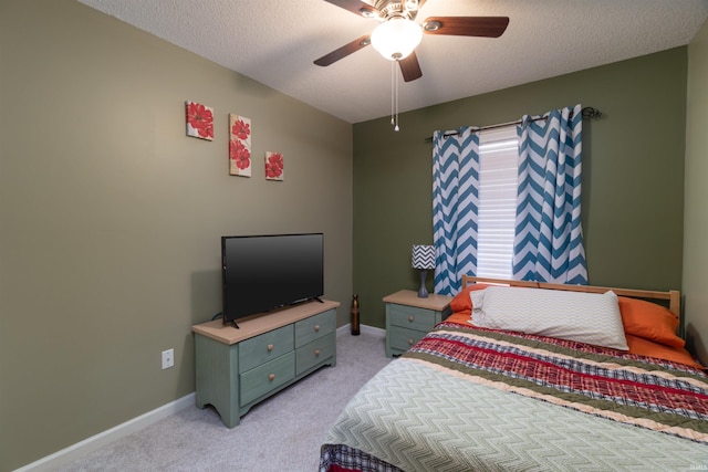 carpeted bedroom featuring ceiling fan and a textured ceiling