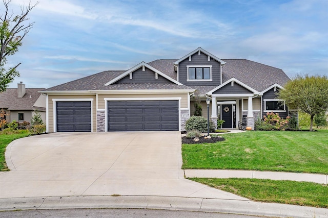 craftsman inspired home with a garage and a front lawn