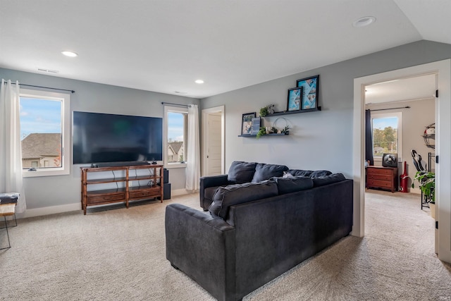 carpeted living room with lofted ceiling and plenty of natural light