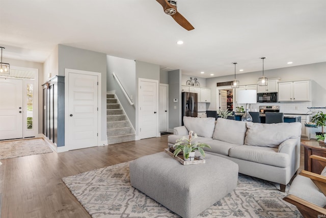 living room featuring ceiling fan and light hardwood / wood-style flooring