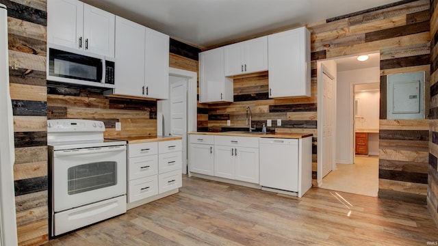 kitchen with sink, white appliances, electric panel, and white cabinets