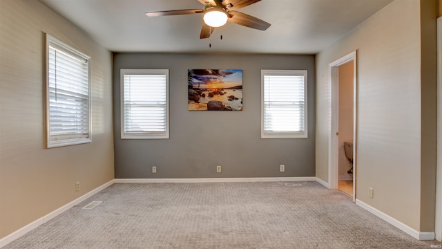 carpeted spare room featuring ceiling fan