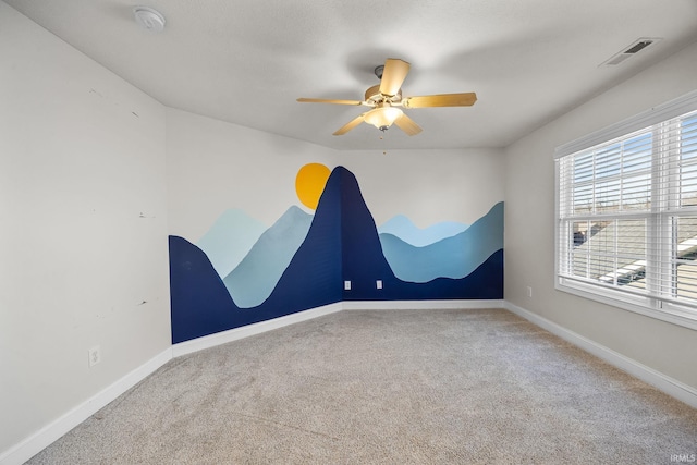 carpeted spare room featuring ceiling fan