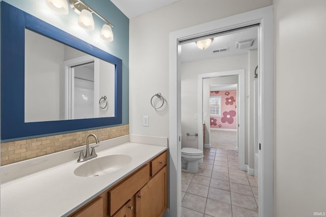 bathroom featuring vanity, toilet, tile patterned flooring, and backsplash