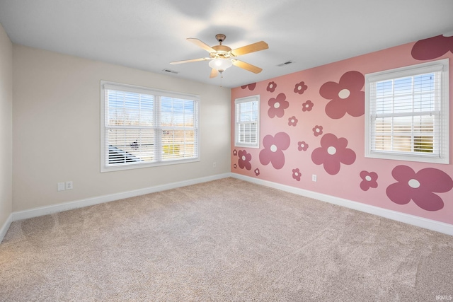 carpeted spare room with ceiling fan