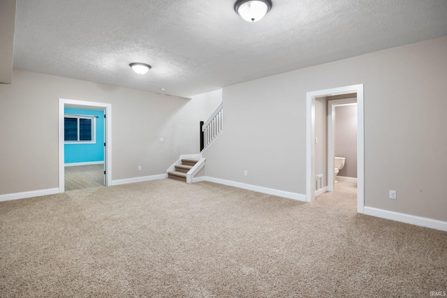 basement featuring a textured ceiling and carpet flooring