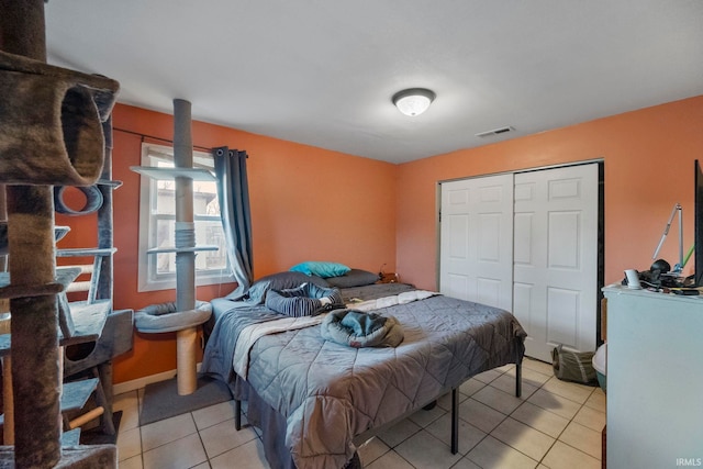 bedroom with a closet and light tile patterned floors