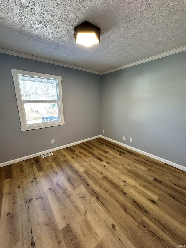 unfurnished room featuring hardwood / wood-style flooring, crown molding, and a textured ceiling