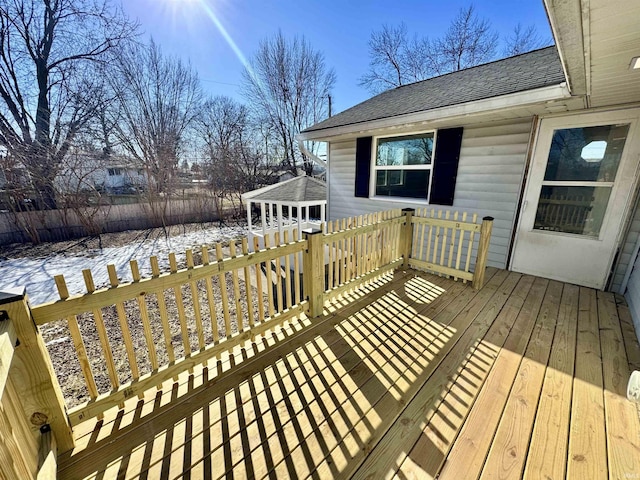 snow covered deck with an outbuilding and a garage