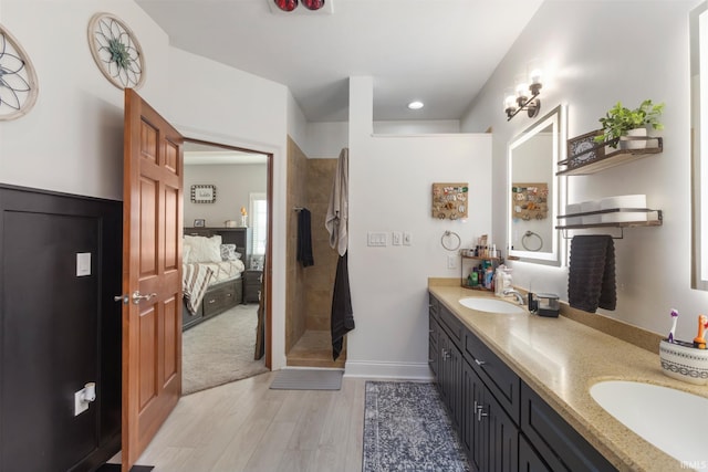 bathroom featuring vanity, hardwood / wood-style floors, and a tile shower