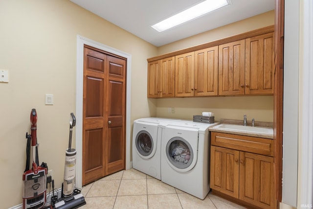 washroom featuring sink, light tile patterned floors, cabinets, and independent washer and dryer