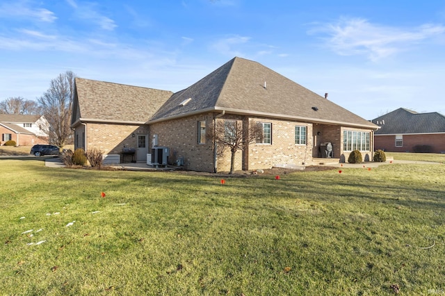 rear view of property with central AC unit, a patio area, and a lawn